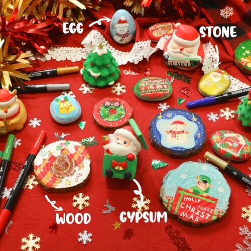 Various Christmas-themed painted objects on a red background, including stones, eggs, wood, and gypsum items with holiday designs.