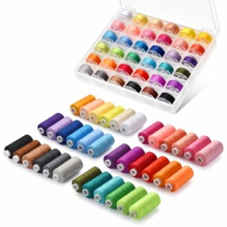 Assorted colorful sewing thread spools in a box and arranged outside.