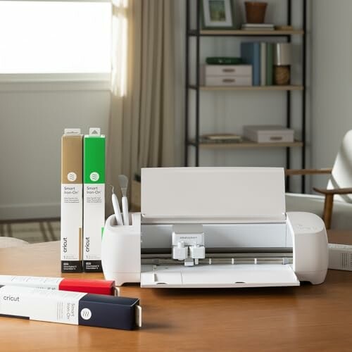 Cricut cutting machine with craft supplies on a table.