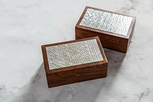 Two wooden boxes with decorative metal lids on a marble surface.