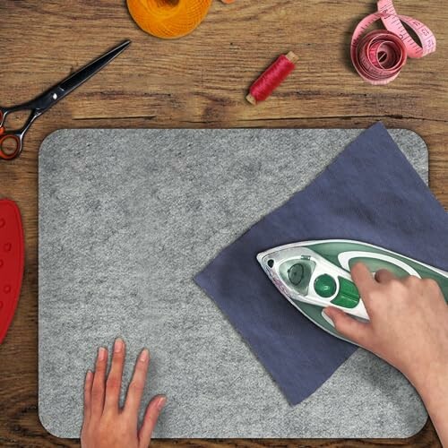Person ironing fabric on wool mat with sewing tools nearby.