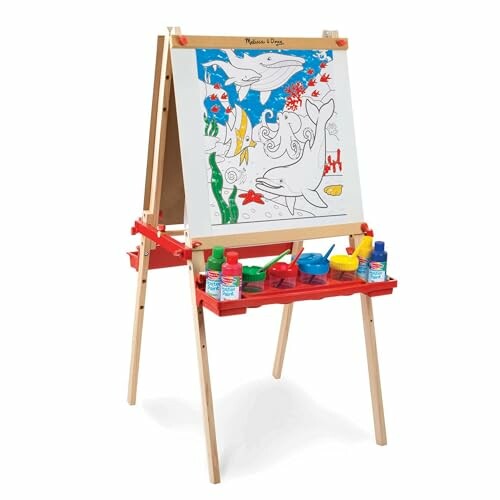 Children's easel with painting supplies and canvas featuring dolphins.