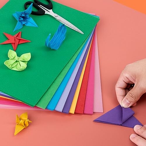 Colorful origami paper, scissors, and folded paper figures.