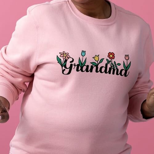 Person wearing pink sweatshirt with 'Grandma' and floral design