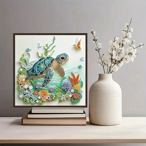 Quilled turtle artwork with flowers on a shelf beside a vase.