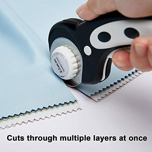 Rotary cutter slicing through multiple fabric layers.