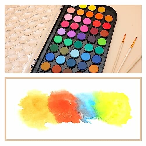Colorful watercolor palette with brushes and abstract paint swatch.