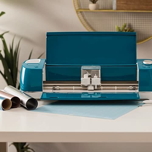 Vinyl cutting machine on a desk with rolls of material nearby