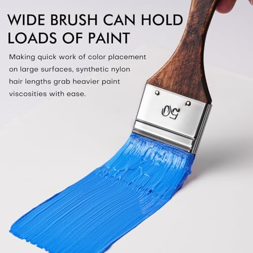 Wide brush painting blue paint on surface.